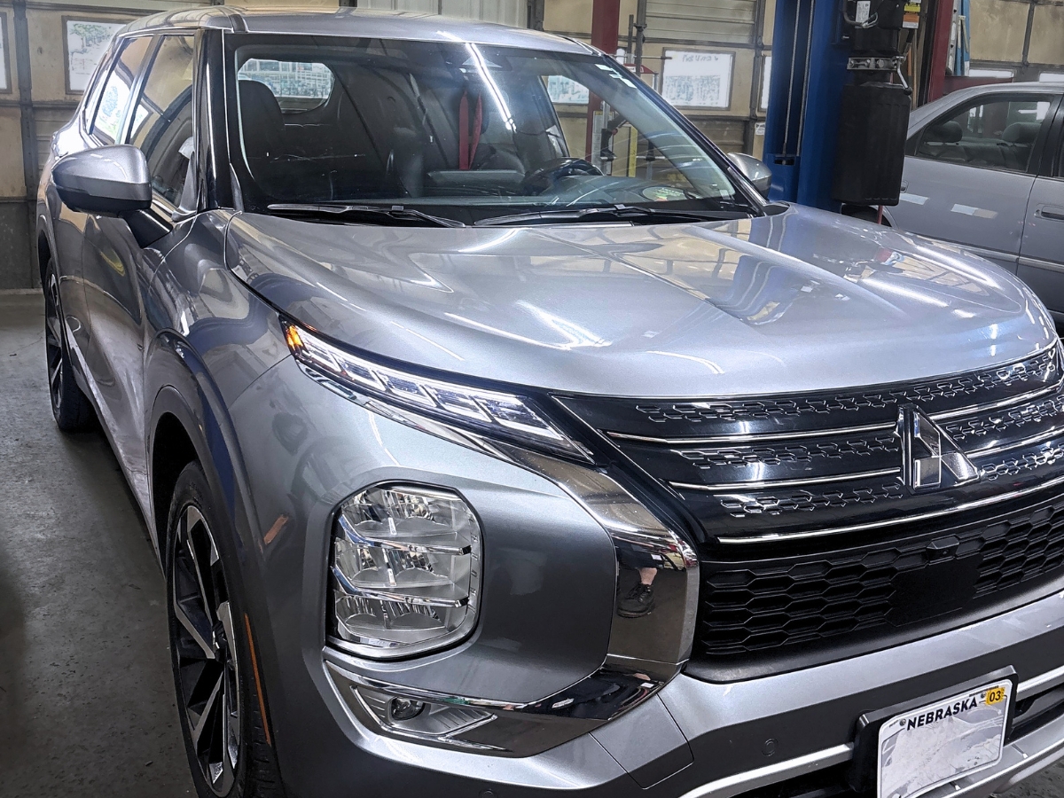 Silver 2024 Mitsubishi Outlander inside a Mad Hatter Auto Repair service bay.