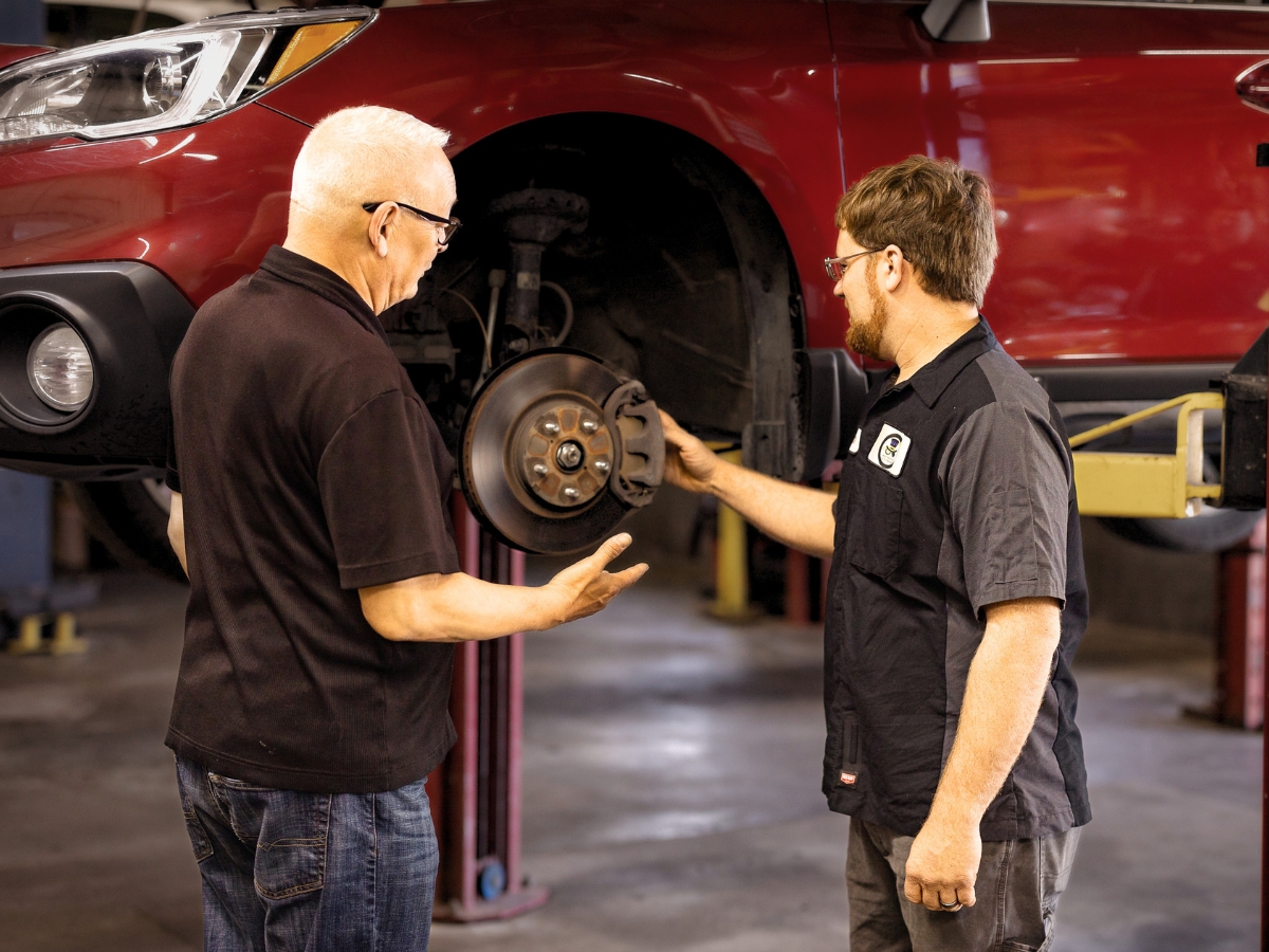 Mad Hatter Auto Repair technicians inspecting brakes and suspension components before summer driving in Council Bluffs, Iowa